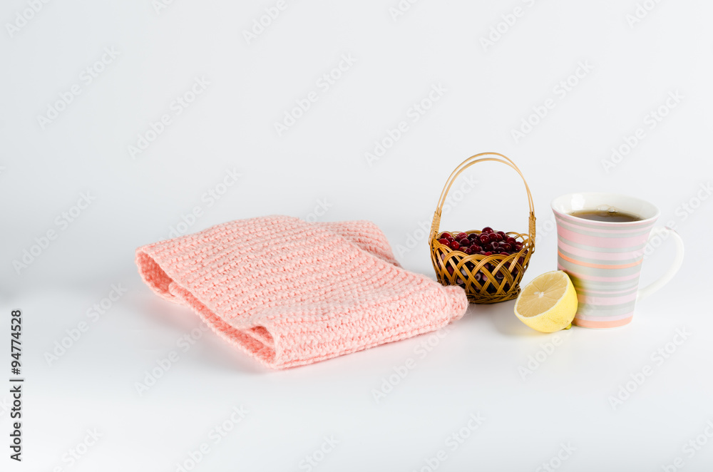 warm scarf, lemon and tea on a white background