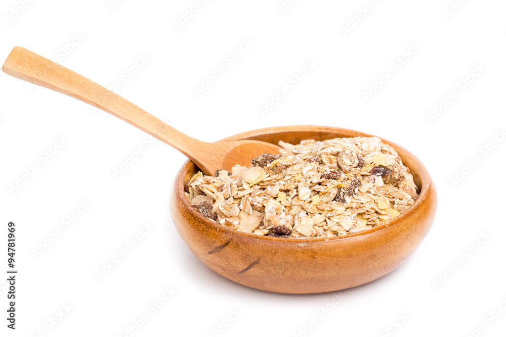Muesli in bowl and wooden spoon on white background Muesli in bowl and wooden spoon on white background