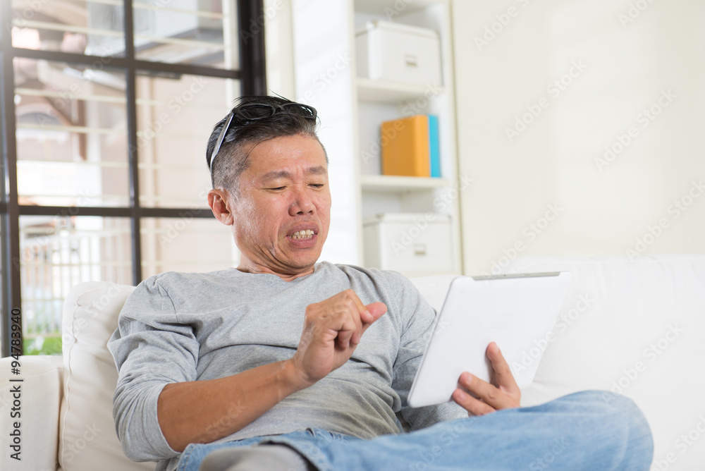 unhappy asian senior using tablet unhappy asian senior using tablet