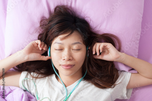 Asian young girl listen to music closed eyes wear headphones