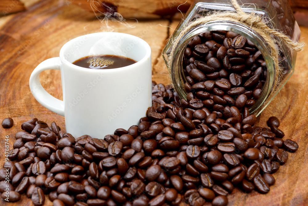 Fototapeta premium Roasted coffee beans on wood and black coffee.
