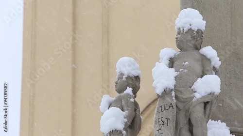 statues of angels outside the church, are ridiculous caps of snow, snowing