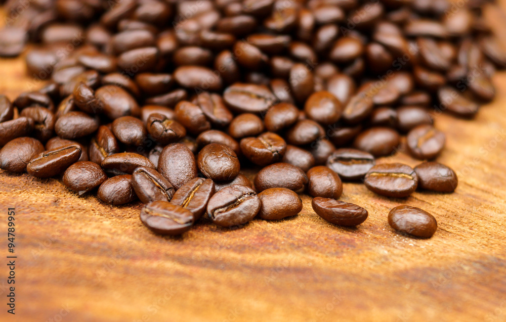 Roasted coffee beans on wood. (Arabica coffee) Roasted coffee beans on wood. (Arabica coffee)