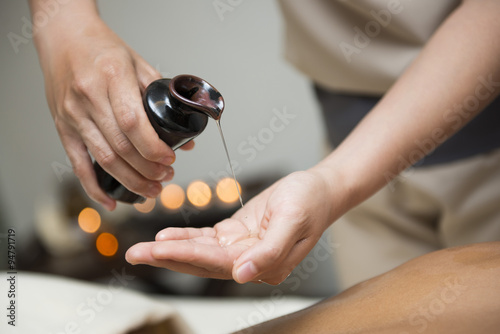 chiropractor pour oil into hand for massage