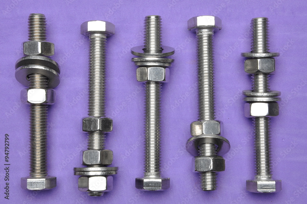 Bolts and nuts on violet background Bolts and nuts on violet background