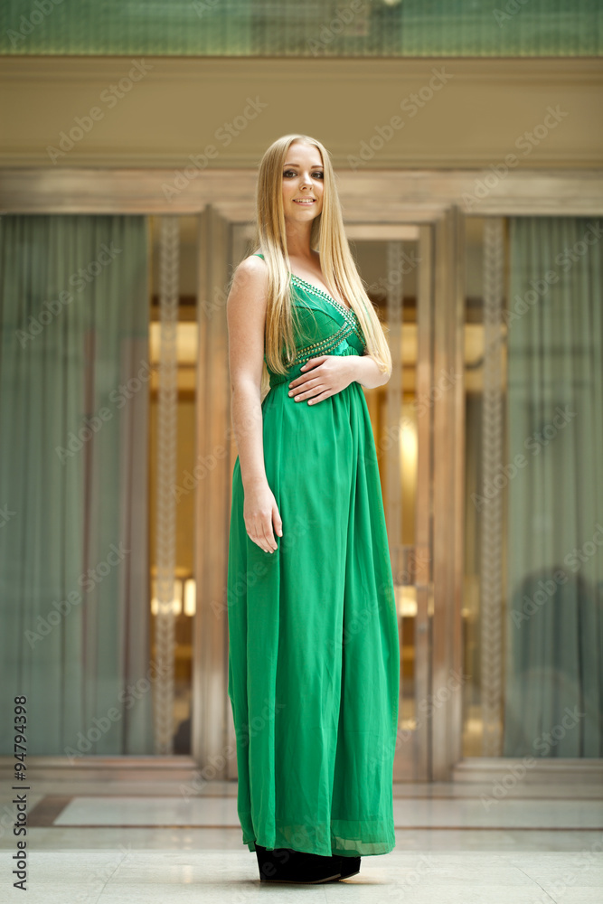 Happy beautiful woman in a long green dress