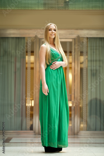 Happy beautiful woman in a long green dress © Andrey_Arkusha