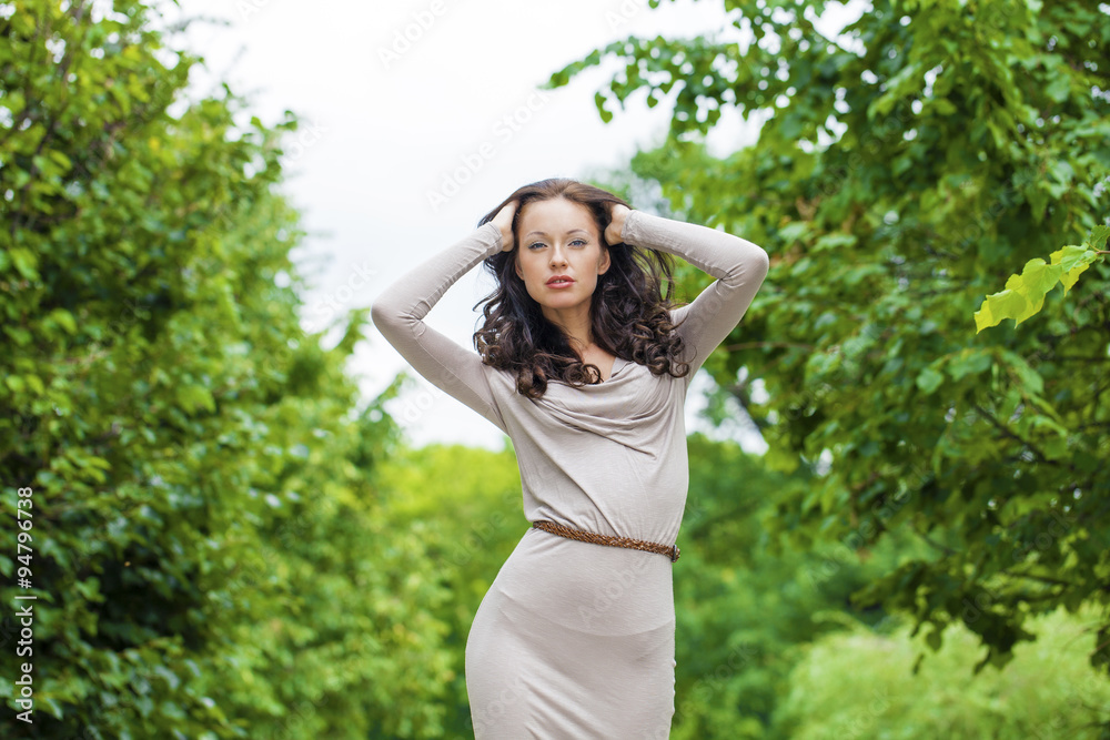 Beautiful young woman in sexy long gray dress in summer park Beautiful young woman in sexy long gray dress in summer park