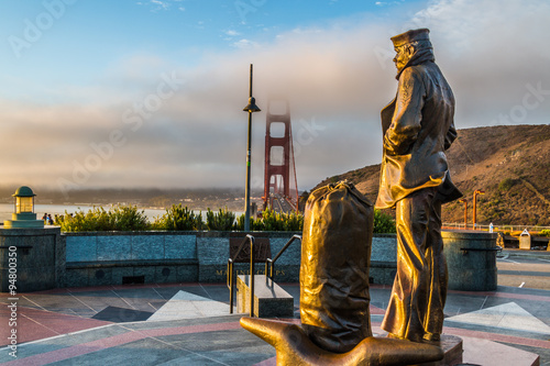 Lone Sailor Memorial Statue, Sausalito, CA, and view of the Golden Gate Bridge during sunrise photo