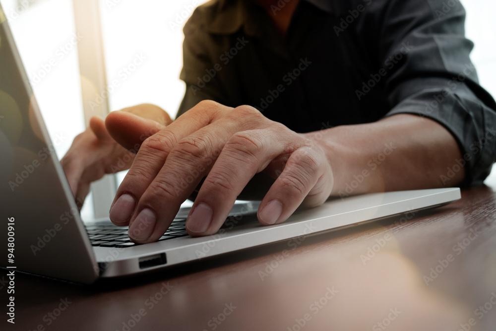 designer hand working and smart phone and laptop on wooden desk designer hand working and smart phone and laptop on wooden desk