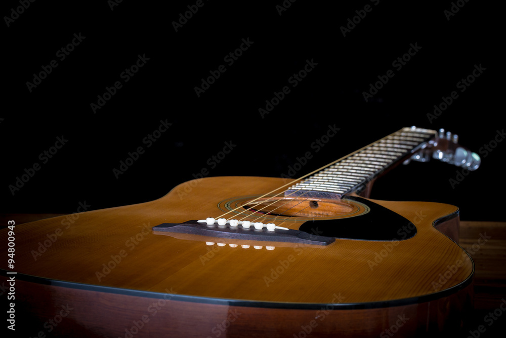 Fototapeta premium acoustic guitar detail on black background