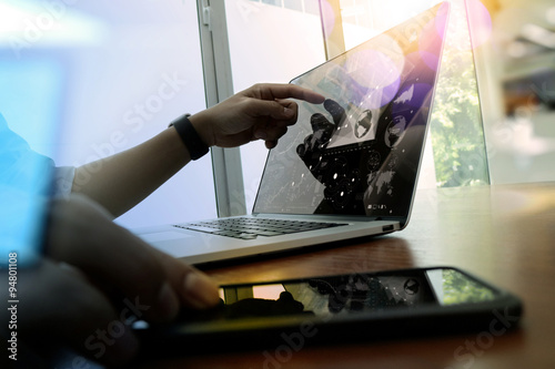Fotografie business man hand working on laptop computer on wooden desk wit