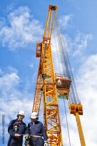 building workers and giant construction crane