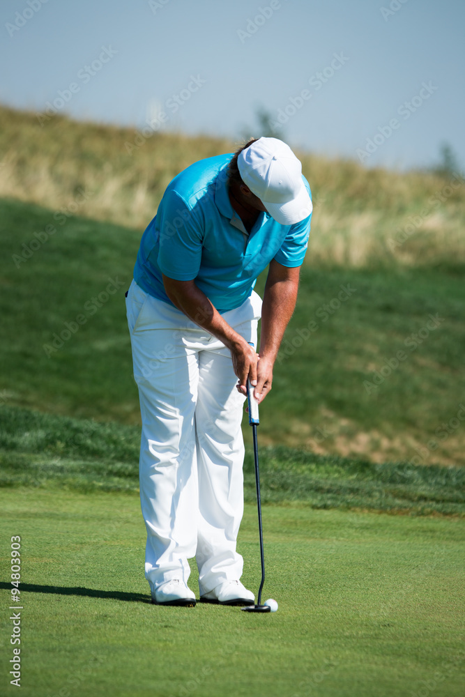 Fototapeta premium Golf player preparing for a putt on the golf green