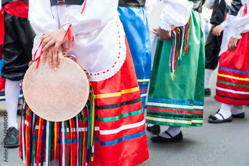 Girl with a typical regional dress holding a colored tambourine during a folkloristic show 