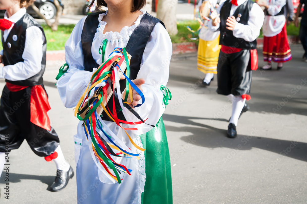 Girl with a typical regional dress playing a colored tambourine during a folkloristic show in Sicily