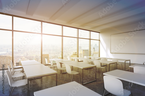 A modern panoramic classroom with New York view. White tables and white chairs. 3D rendering. Sunset. Toned image. © ImageFlow