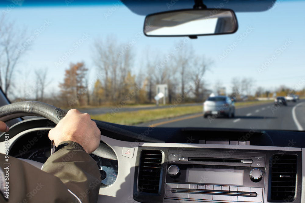 Hand of man driving on a highway. Hand of man driving on a highway.