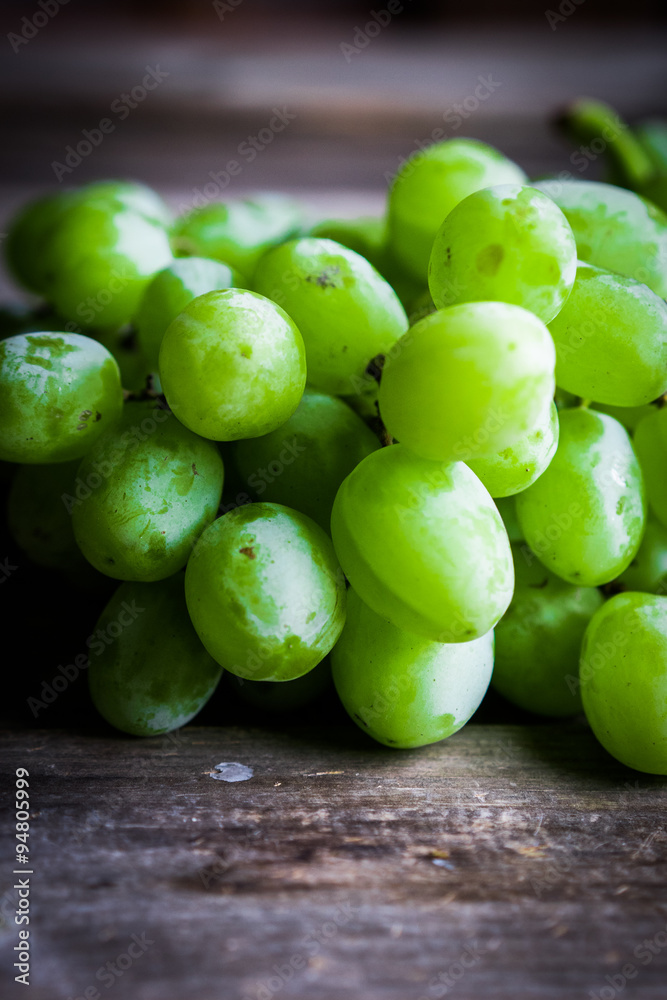 Vine of green grapes on rustic wooden background Vine of green grapes on rustic wooden background