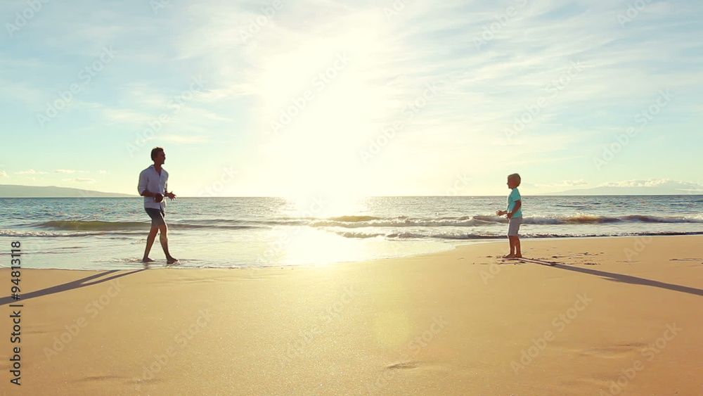 Father and Son Playing Together at the Beach at Sunset. Father Teaches Son to Throw Football Father and Son Playing Together at the Beach at Sunset. Father Teaches Son to Throw Football