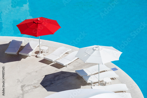 Sun umbrellas and beds near swimming pool at poolside