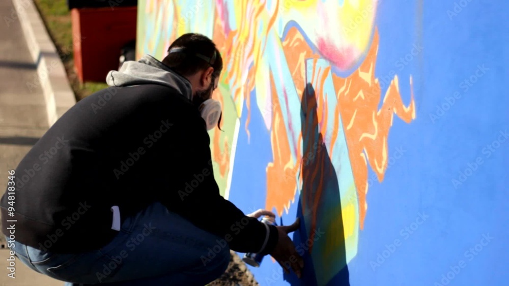 Hip Hop Rap artist with a beard and mask Teenager make graffiti on the wall Hip Hop Rap artist with a beard and mask Teenager make graffiti on the wall