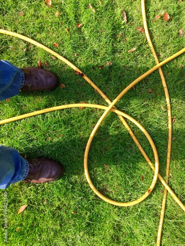 Standing on the lawn by a hose