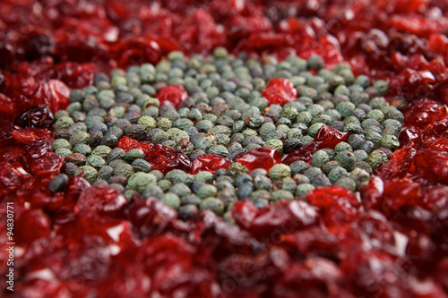 Smiling face mosaic made of cranberry and green pepper