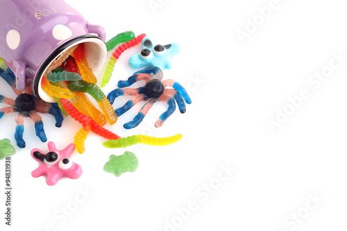 colorful jelly candies in the shape of a worm and a spider in the can isolated on white background