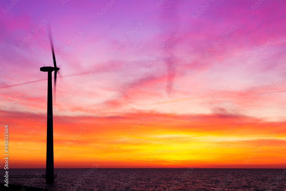 Beautiful sunset at the dike with wind turbines at the Markermeer in the Netherlands 