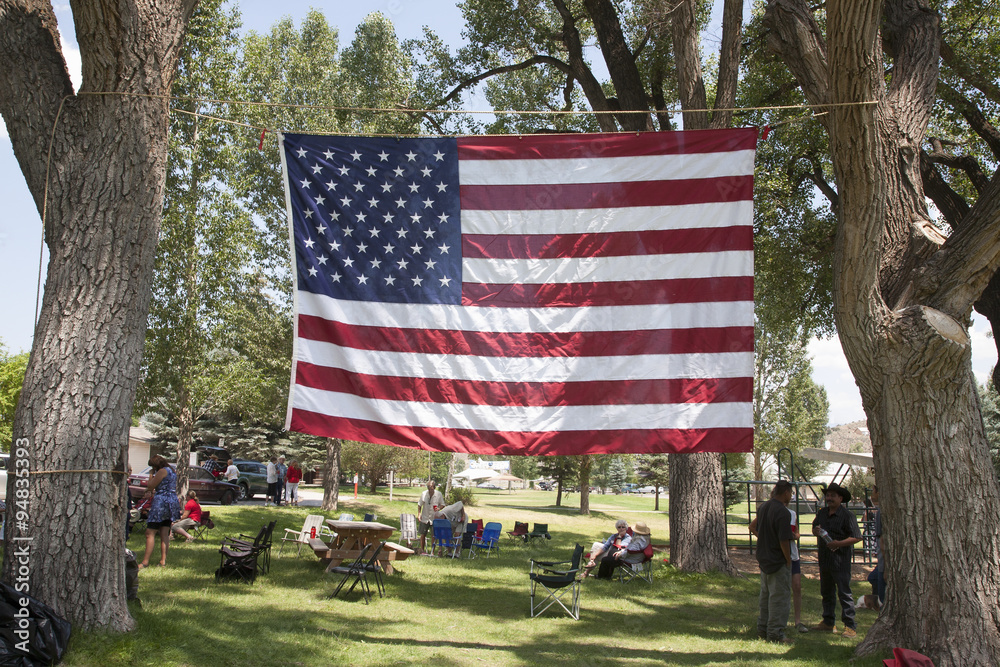 US Flag stretched between trees in Town Park of Ridgway Colorado.
