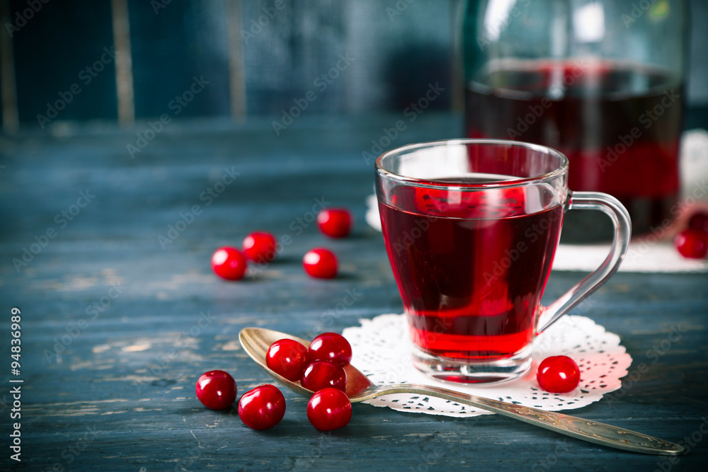 Sweet homemade cherry juice on table, on color wooden background Sweet homemade cherry juice on table, on color wooden background