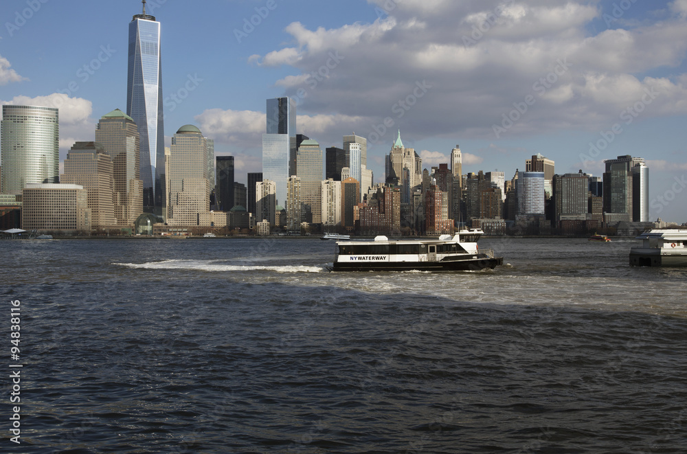 From New Jersey, a water taxi is seen in front of New York City Skyline featuring One World Trade Center (1WTC), Freedom Tower, New York City, New York, USA, 03.20.2014