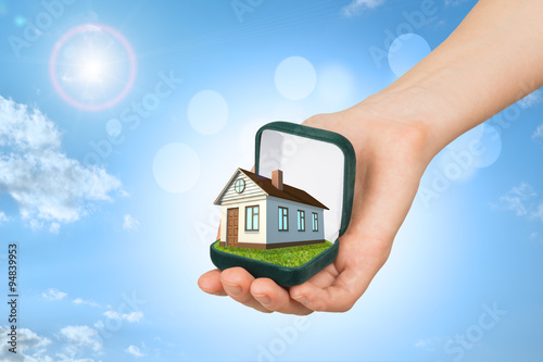 Empty ring box with brown house in humans hand