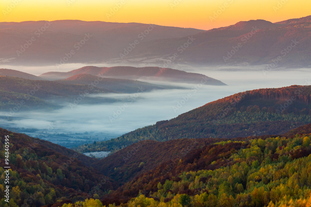 cold morning fog with red hot sunrise in the mountains in the morning