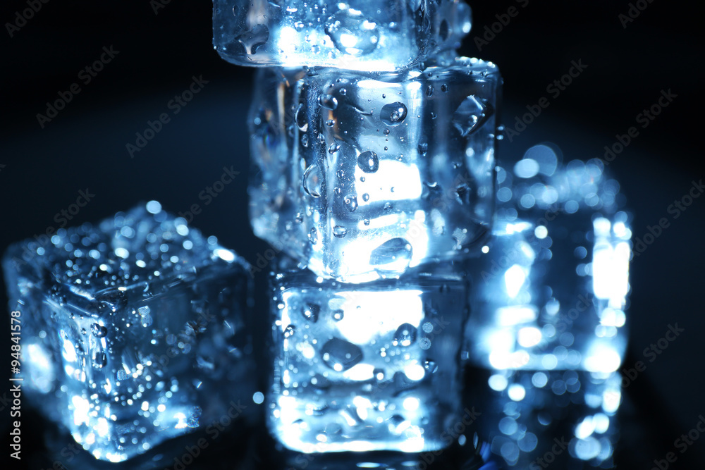 Shining ice cubes under blue light on liquid background Shining ice cubes under blue light on liquid background
