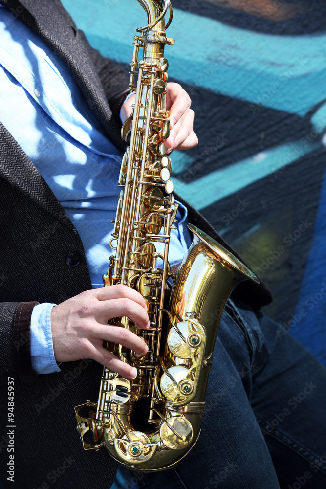 Obraz premium Saxophonist plays jazz on the street, close up