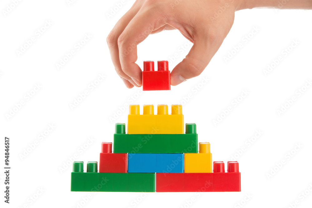 hand building up a wall by stacking up lego, business conception Stock  Photo | Adobe Stock