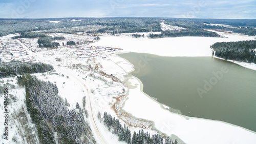 winter aerial photo of the river, forests, village and grey sky