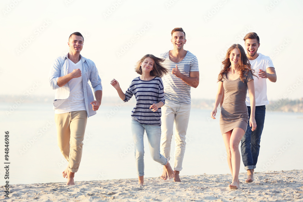 Obraz premium Young people with beer on the riverside