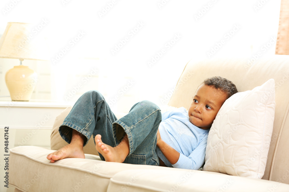 Little boy sitting on sofa in the room