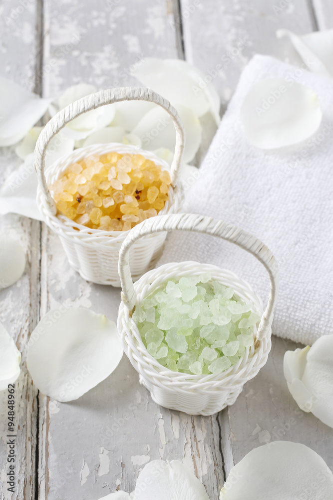 Sea salt in wicker baskets among white rose petals Sea salt in wicker baskets among white rose petals