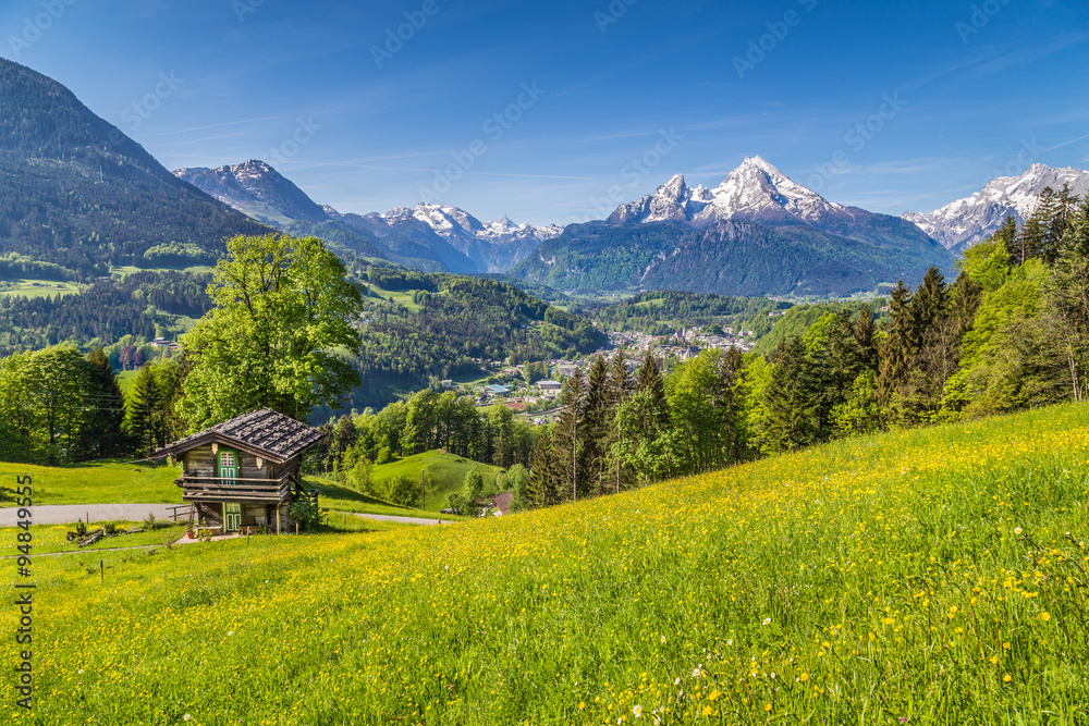 Idyllic landscape in the Alps with traditional mountain lodge in springtime