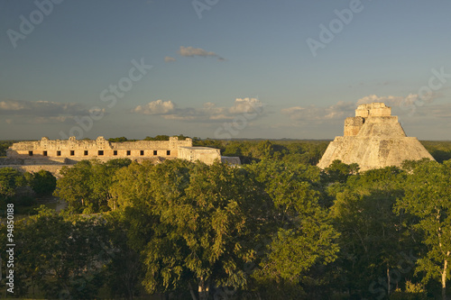 A panoramic view from left to right: Nunnery Quadrangle and the Pyramid of the Magician, Mayan ruin of Uxmal at sunset in the Yucatan Peninsula, Mexico