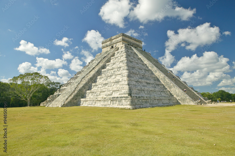 White puffy clouds over the Mayan Pyramid of Kukulkan (also known as El Castillo) and ruins at Chichen Itza, Yucatan Peninsula, Mexico