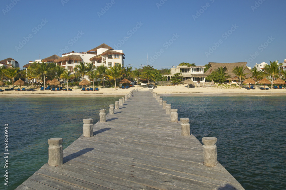 Dock in water looks back at Puerto Morelos, Mexico, South of Cancun in the Yucatan Peninsula, Mexico