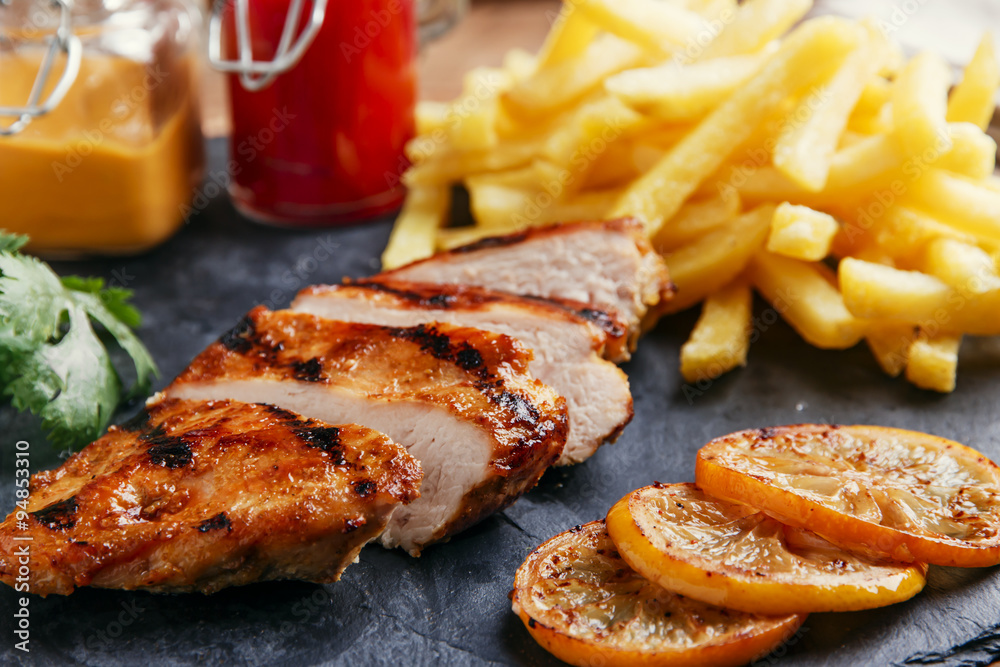 Grilled chicken breast with french fries and sauce