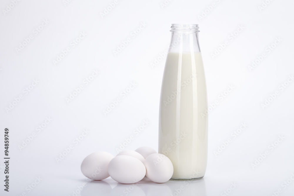 Glass bottle of milk and eggs on a white background Glass bottle of milk and eggs on a white background
