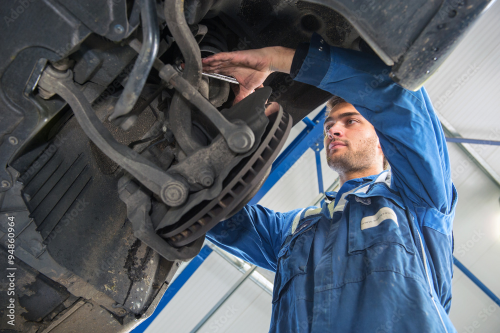 Mechanic at work on the suspension system of a car Mechanic at work on the suspension system of a car