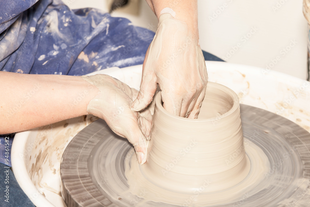 Female Potter creating a earthen jar on a Potter's wheel